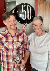 David and me standing, holding 50th balloon.